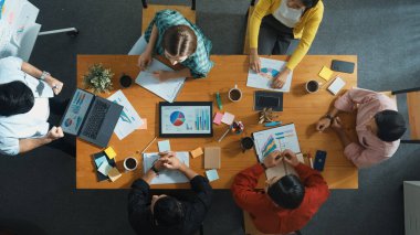 Akıllı bir iş adamının pazarlama fikrini yazarken ve sunarken ayakta durmasının en iyi görüntüsü. Bir grup mutlu insan borsa grafiklerine ve dinleme sunumlarına bakıyor. Cemaat.