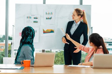 Çok kültürlü çalışma grubu. Farklı etnik kökenden iş kadınları, Kafkasyalı, Asyalı ve Araplardan oluşan bir ekip ofiste dizüstü bilgisayarla birlikte çalışıyor. Çok ırklı takım çalışması konsepti. uds
