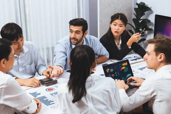 stock image Analyst team utilizing BI Fintech to analyze financial data at table in meeting room. Businesspeople analyzing BI dashboard power on paper for business insight and strategic marketing planning.Prudent