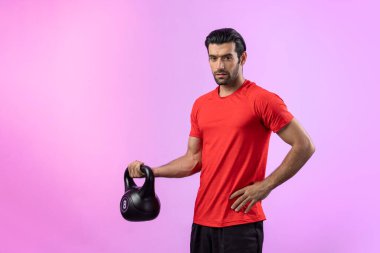 Vücut geliştirme egzersizi için ağırlık kaldırmak için kettlebell kullanan atletik ve sportif bir adam izole edilmiş arka planda ayakta duruyor. Sağlıklı aktif ve vücut bakımı yaşam tarzı