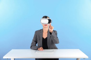 Klavyeli masada otururken VR gözlük takan akıllı bir yönetici. İş kadını giysi ve görsel gerçeklik kulaklığı kullanarak veri analizini yönetmeye çalışıyor ve metaevrene giriyor. Kısıtlanma.