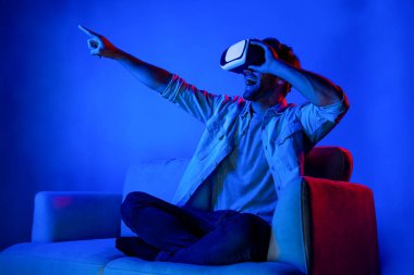 İnsan sanal gerçeklik gözlüğü kullanarak programı simüle ediyor ve seçiyor. Fütürist teknoloji ekipmanları kullanarak sanal dünyaya girerken koltukta oturan kulaklıklı biri. Sapma.