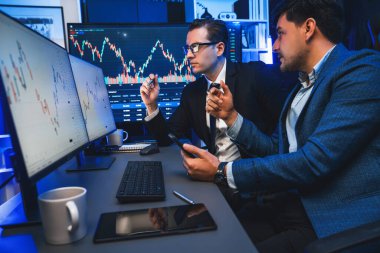 İki borsa simsarı gece monitörde döviz kurunda dinamik yatırım grafiğini tartışıyor. İş adamı ortakları iş yerindeki neon ışığı altında yüksek borsada kahve toplantısı yapıyor. Satılabilir.