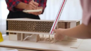 Mimari ekipman incelemesi kullanarak yavaş çekim ev tasarımcısı ve müşteri veya müşteriyle birlikte mimari ev modeli tasarım örneklerini ölçer. Filizlenen