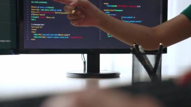 Yavaş çekim arkası yazılım geliştirici mühendisi bilgisayar programlama için birlikte çalışarak hata ayıklama kodunu çözüyor, ofiste monitörde karmaşık algoritmaları çözüyor. Filizlenen