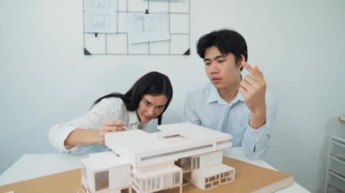 Profesyonel akıllı iş birliği mühendisi mühendis ekibi modern ofisteki ev yapısını planla kontrol ederken genç ve güzel proje yöneticisi not alıyor. Yaratıcı tasarım konsepti. Tertemiz...
