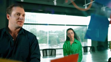 Profesyonel iş adamları yaratıcı pazarlama fikrini modern ofiste tartışırlar. İş adamları cam tahtada yapışkan notlar kullanarak finansal plan üzerinde çalışıyor. Yönlendirici.