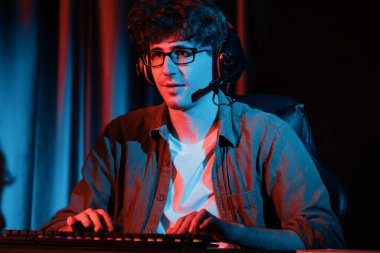 Stresli genç oyun flaması takımı, Esport ile çevrimiçi olarak bilgisayar üzerinde daha sert oyun seviyesine odaklanmış ve neon aydınlatma odasında strateji planı uygulamak için sürpriz yüz ifadesiyle kazanmayı denemiştir. Toplayıcı.