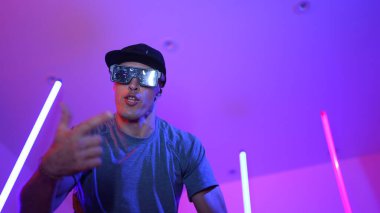 Beyaz dansçının gösterişli gözlükler taktığı ve break dans yaptığı alçak açılı kamera. Çekici adam kendinden emin bir şekilde kameraya bakarken enerjik bir performans ve hareket gösterdi. Mutluluk.