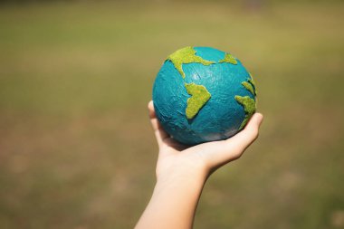 Dünya gezegenini ESG ilkesi ve çevre dostu enerjisiyle daha parlak bir gelecek için Dünya günü olarak el ele tutuşan genç çocuklar. Döngü