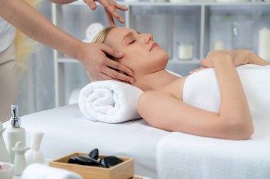 Kafkasyalı kadın stres önleyici kafa masajından ve lüks tatil beldesi ya da otel spa salonundaki modern ışık ortamında yüz güzelliği eğlencelerini şımartmaktan hoşlanıyor. Sessiz.