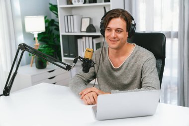 Sunucu kanalı, gülümseyen akıllı yayıncı kaydı, senaryosu ve akıllı telefonuyla sosyal medyada sohbet programı, kulaklık takarak modern ev stüdyosundaki video flamalarını kaydediyor. Bireysel.