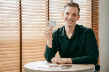 Genç adam internet bankacılığı için kredi kartlı dizüstü bilgisayar kullanıyor. İnternet üzerinden alışveriş yapıyor. Banka kartıyla modern ve kullanışlı online satın alma. Açılıyor