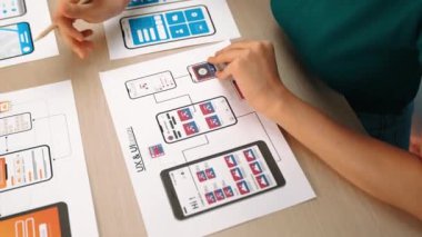 Mobil uygulama için kullanıcı arayüzü prototipi ya da masadaki program modeliyle birlikte web sitesi planlaması yapan bir şirket çalışanı. UX UI tasarımcısı kullanıcı dostu arayüz planını dikkate alır. Sinerjik