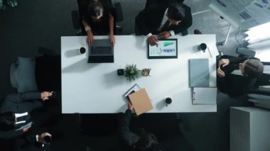 Çeşitli pazarlama ekipleri iş toplantısına hazırlanıyor. İş adamlarının yukarıdan aşağıya havadan görüşü masaya dizilmiş dizüstü bilgisayar ve tablet ile mali istatistikler. Yaratıcı iş. Müdürlük.