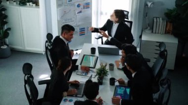 Akıllı yönetici projesinin üst görünümü beyaz tahtaya zihin haritası ve finansal grafik ile işaret ediyor ve çeşitli yatırımcılar hisse yatırım grafiğini dinleyip analiz ederken pazarlama fikrini açıklıyor. Müdürlük.