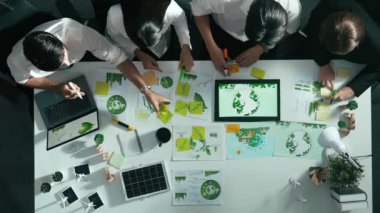 Yönetici yöneticisinin üst görünümü toplantılarda tablet temiz enerji gösterir. İş adamlarının sürdürülebilir çevre yatırımlarını planlamak ve yatırım yapmak için birlikte çalıştıklarına dair havadan bir bakış açısı. Hizalama.