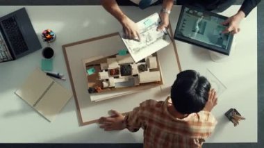 Yöneticinin zaman aşımı ev modelini gösteriyor ve bina tasarımını açıklıyor. Tablet ev planı sergilenirken iç yapı hakkında beyin fırtınası yapan mimar mühendisinin hava görüntüsü. Hizalama.