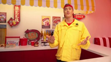 Kafkasyalı restoran çalışanı dans ederken ve serbest stil müzik eşliğinde dans ederken sofraya yemek koyarken mutlu ol. Profesyonel yetenekli garson yemek barının arkasında beklerken müşteriler için yemek hazırlar. Mutluluk.