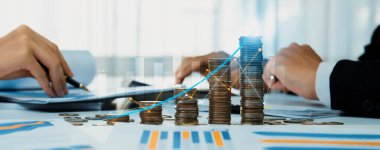 Dijital grafik göstergeli bozuk para yığını iş yatırımını ve ekonomik büyümeyi sembolize ediyor. Finansal hedefe ulaşmak ve kâr sağlamak için finansal planlama yapan bir iş adamı. Kurnaz.