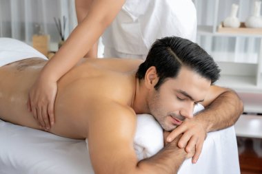 Kafkas erkek müşteri stres önleyici spa masajının keyfini çıkarıyor ve lüks otel veya oteldeki gündüz açık hava ortamında güzellik derisi eğlencesi ile şımartıyor. Sessiz.