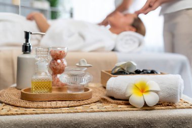 Aromaterapi masajı gündüz atmosferinde ya da spa salonunda bulanık bir kadına odak dekor ve spa aksesuarları kurarak tatil köyünde ya da otel arka planında keyifli aroma spa masajı yapan bir masaj. Sessiz.