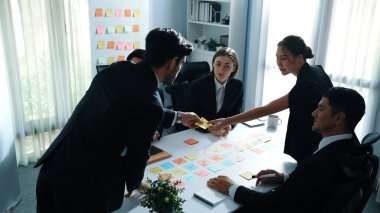 Akıllı iş adamlarının toplantı odasında pazarlama ekibinin yaratıcı fikirlerini anlatırken tahtaya yapışkan notlar yapıştırdığı en iyi manzara. Lider, başlangıç projesini çeşitli yatırımcılara açıkladı. Müdürlük.