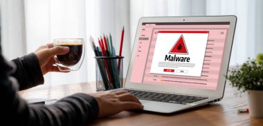 Cyber attacking concept. Malware alert showing on computer screen display scam and threat detection on computer system or online server to be removed snugly.
