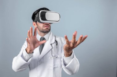 Zeki doktor, kameraya bakıyor ve beyaz arka planda duruyor. Sanal gerçeklik ya da metadünya giyerken tıbbi verileri elinde tutan ve kontrol eden beyaz bir doktor. Yenilik teknolojisi. Sapma.