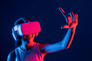 Etrafı neon ışıklı kulaklıklarla çevrili bir kadın metaevreni bağlayan VR kulaklık takıyor, fütüristik siber uzay topluluk teknolojisi yayıyor, işaret ve başparmak ile sanal nesne etkileşimi kuruyor. Halüsinasyon.