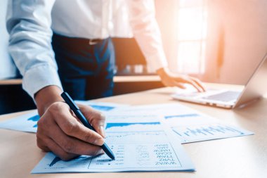 İş adamı muhasebeci ya da finans uzmanı şirket ofisindeki iş raporu grafiğini ve finans şemasını analiz eder. Finans ekonomisi, bankacılık sektörü ve borsa araştırmaları kavramı. uds