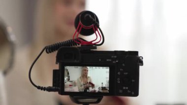 Güzellik ve kozmetik öğretim videosu içeriği yapan kamera görüntüsü kadını ya da perde arkası görüntüsü. Güzellik blogcusu izleyicilere ya da sosyal medya takipçilerine güzellik hizmetinin nasıl uygulanacağını gösteriyor. Blithe