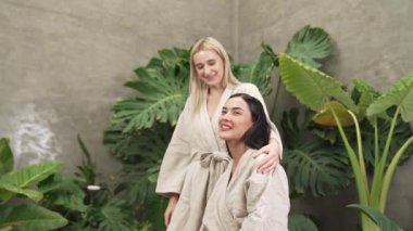 Modern otelde küveti olan tropikal ve egzotik bir spa bahçesi mi yoksa yemyeşil yeşillik arka planıyla çevrili rahat ve sağlıklı yaşam tarzının tadını çıkaran bornozlu iki genç kadınla tatil köyü mü? Blithe