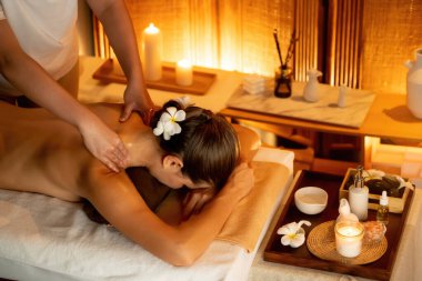 Beyaz kadın müşteri stres önleyici spa masajının keyfini çıkarıyor ve lüks otel ya da otelde sıcak mum ışığında güzellik teniyle eğleniyor. Sessiz.
