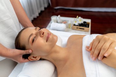 Kafkasyalı kadın stres önleyici kafa masajından ve lüks tatil beldesi ya da otel spa salonundaki modern ışık ortamında yüz güzelliği eğlencelerini şımartmaktan hoşlanıyor. Sessiz.