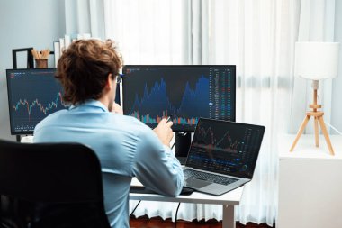 Genç yatırımcı, dinamik döviz kurunu dizüstü bilgisayarda ve bilgisayar ekranındaki dinamik piyasa grafiğinde, gerçek zamanlı olarak modern ev ofisteki finansal teknoloji verilerini analiz ederek gösteriyor. Toplayıcı.