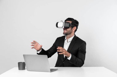 Bilgisayarla masada otururken ve VR gözlüğü takarken veri analizine bakan yetenekli bir iş adamı. Proje yöneticisi sanal gerçeklik sistemini kullanarak ya da metaevrende bağlantı kurarak çalışıyor. Sapma.