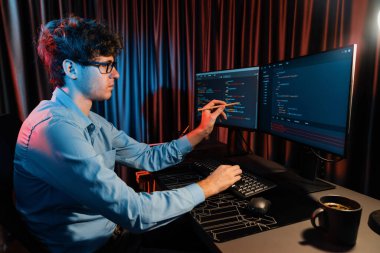 Bilgisayardaki yazılım geliştirme kodlamasını yan görüntüde pc ekranda gösteren IT geliştiricisi, neon modern ofisteki web sitesinde en son sürüm uygulaması için tasarlanmış yeni bir program üzerinde çalışıyor. Toplayıcı.