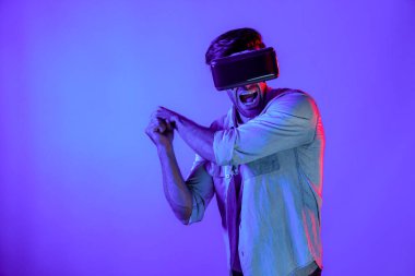 Kafkasyalı bir adam VR cam takıyor ve hareket eden el kol kılıcını tutuyor. Oyuncu, gelecekteki sanal gerçeklik kulaklığını ya da gelecekteki yenilikleri kullanarak meta dünyaya giriyor ya da aksiyon oyunu oynuyor. Sapma.