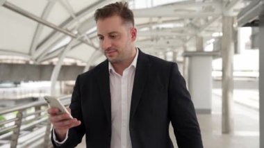 Briçte iş yerine giderken cep telefonunu kontrol eden yetenekli bir işadamı. Mutlu yönetici, pazarlama ekibine masaj yapmak ve iyi haberler almak için telefonu kullanıyor. Urbane.