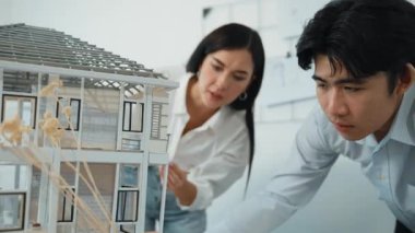 Profesyonel kooperatif beyaz mimar mühendis ekibi ev modelini dikkatle incelerken beyaz modern ofisteki model yapısı hakkında tartışırlar. Yaratıcı karar ve takım çalışması. - Yakın çekim. Tertemiz..