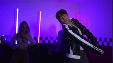 Kameranın önünde dans eden yetenekli break dansçı farklı arkadaşları pop ya da hip hop müziği dinlemek için arkada dans ediyor. Çekici performans ekibi kameraya doğru hareketli hareketler sergiliyor. Mutluluk.