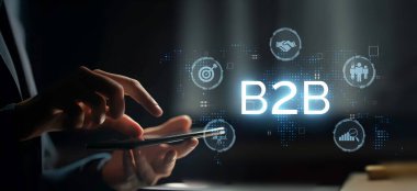 İş adamı B2B peyzajında geziniyor, iş ile iş arasındaki bağlantıları geliştirmek için teknolojiyi kullanıyor. B2B etkileşimlerini yeniden şekillendiren, iş-iş stratejilerinde yeniliği teşvik eden keşifler