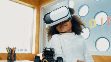 Meta-evrende öğrenmek için VR kulaklık takan yaratıcı kız. Komik çocuk yapay zeka kulaklığı takıp BTMM teknoloji sınıfında sanal dünya programına katılmayı seviyor. Yenilik. Gelecekteki yaşam tarzı. Etkinlik.