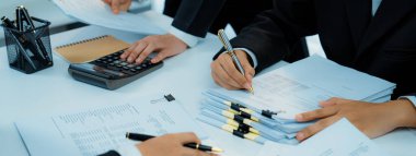 Kurumsal muhasebeci ekibi vergi iadelerini hesaplamak ve en yüksek seviyeye çıkarmak için hesap makinesi kullanır ve finansal veri raporuna dayanarak finansal performansı artırır. Panorama 'daki modern muhasebe. Kurnaz.