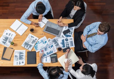 Panorama üst düzey iş analist grubu toplantı masasındaki finansal veri raporunu analiz ediyor. İş zekası analizine göre çizelge ve grafik paneli. Çok titiz.