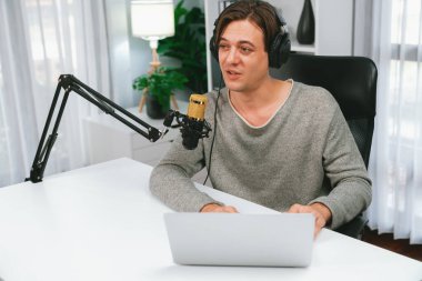 Sunucu kanalı, gülümseyen akıllı yayıncı kaydı, senaryosu ve akıllı telefonuyla sosyal medyada sohbet programı, kulaklık takarak modern ev stüdyosundaki video flamalarını kaydediyor. Bireysel.