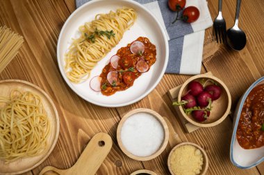 Lezzetli yiyecekler, ev yapımı spagetti, kıymalı domates sosu ve fesleğen fırlatma elementleri, şef masası dekoratif baharatlarla servis ediliyor. Varsayım.
