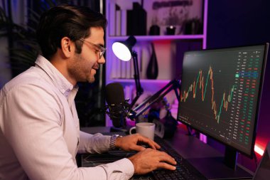 Akıllı tüccar işadamı, karanlık oda gecesinde neon ışıklı ofisteki arama pazarında yüksek kârla ekranda bilgisayar ve bilgisayar üzerinde dinamik borsa yatırımları üzerinde yoğunlaşıyor. Tahmin et..