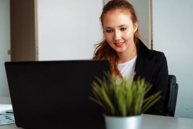 Genç iş kadını ofis masasında dizüstü bilgisayarla çalışıyor. İş dünyası internet kavramı. uds